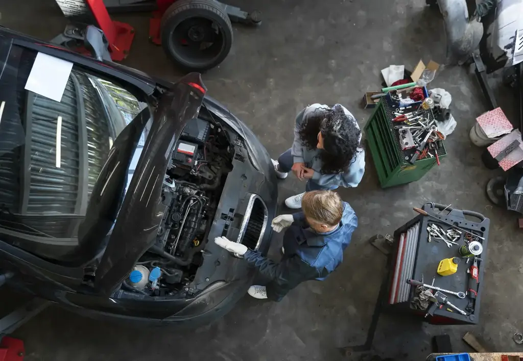 Deux mécaniciens réparant une auto