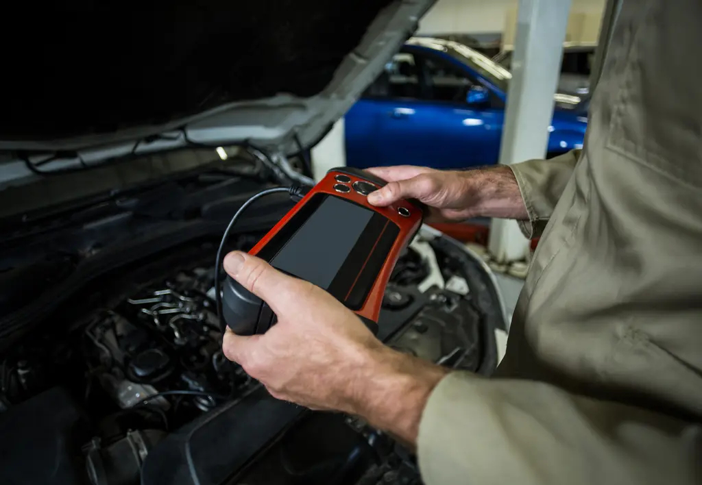 Homme tenant un outil de diagnostique OBD