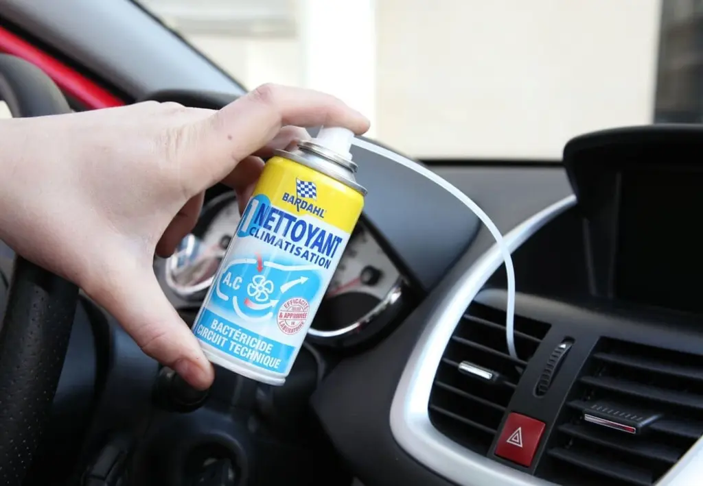 Main tenant un spray de désinfection de climatisation